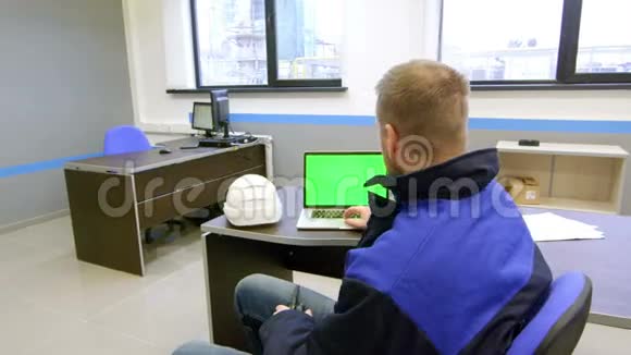 工程师看着绿色的屏幕在控制室里用对讲机交谈视频的预览图