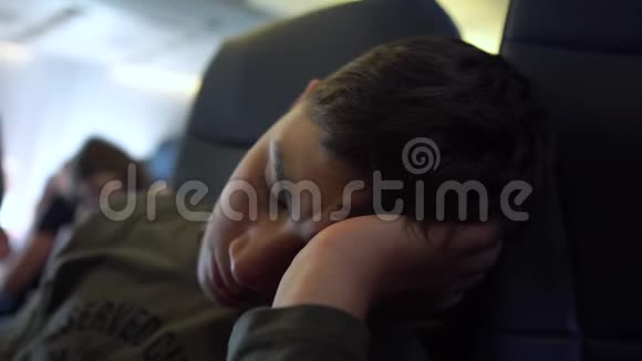 4K青少年在飞机上靠在手臂上睡觉视频的预览图