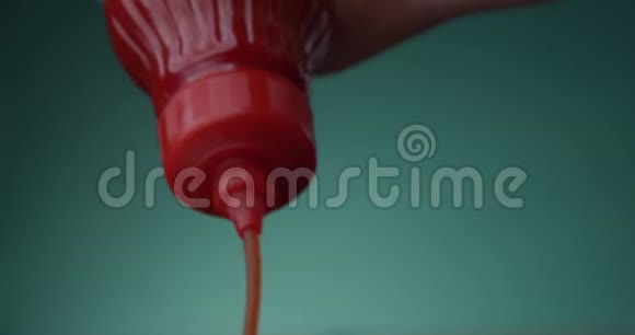 番茄水壶被挤压从一个红瓶一个特写在一个饼干绿色的水水门主题颜色背景视频的预览图