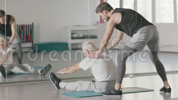 老年人在健身房镜子前做伸展运动视频的预览图