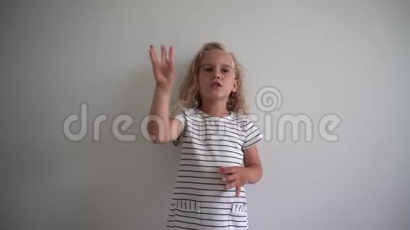 快乐认真的女孩试着在白色的墙壁背景上数数手指万向节运动视频的预览图
