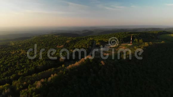 无人机射击森林景观山谷山顶的无线电塔日落视频的预览图