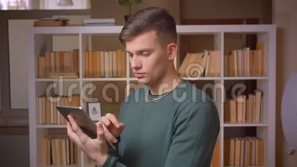 一幅年轻的男学生专心工作平板电脑专心工作对图书馆感兴趣的肖像视频的预览图