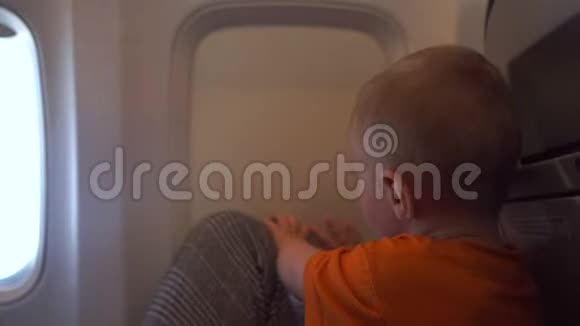 婴儿正试图打开飞机上的窗帘窗视频的预览图