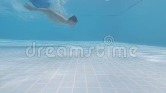 这个男孩在游泳池里的水下游泳然后拿着一个动作摄像机出现了视频的预览图