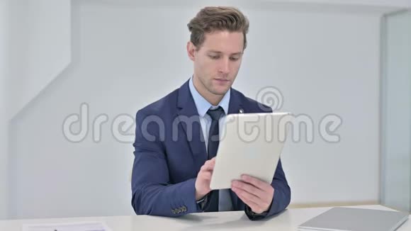 工作勤奋的年轻商人在办公室使用平板电脑视频的预览图