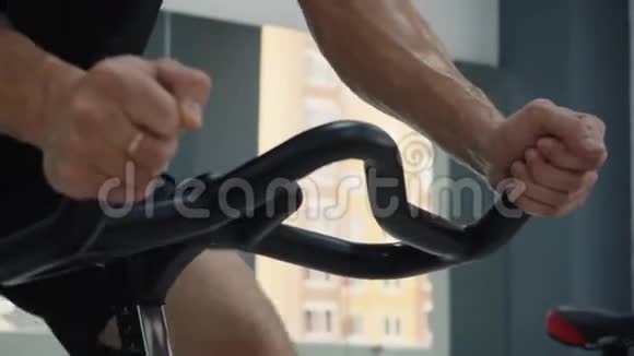 骑自行车课上男性出汗手拿手柄室内自行车有氧运动训练中男性汗湿双手视频的预览图