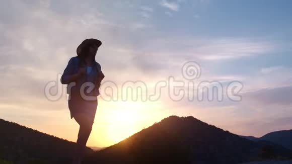 主动徒步旅行的女游客在日落时低角度的高山上散步视频的预览图