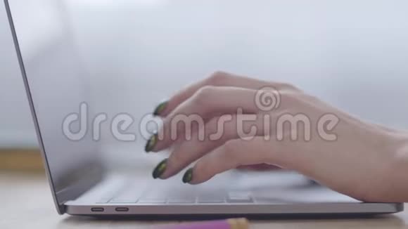 在笔记本电脑键盘上快速输入女性白种人的双手办公室工作现代技术在线视频的预览图