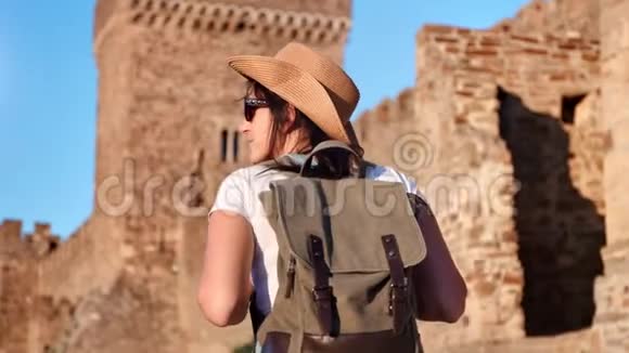 背包客旅游活动妇女攀登中世纪城堡墙欣赏景观后景视频的预览图