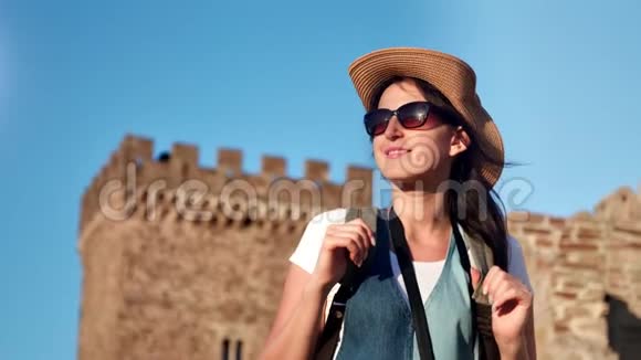 中度特写迷人的微笑年轻的旅行妇女戴着帽子和太阳镜享受户外日落视频的预览图