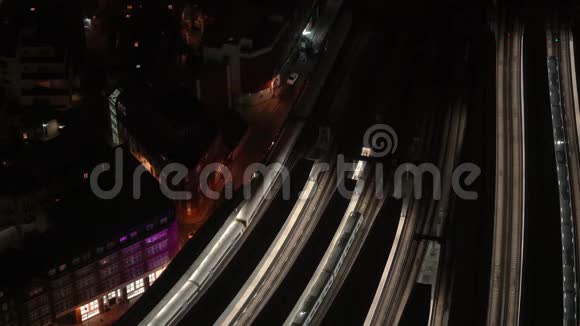 火车站的空中夜景火车从明亮的站台缓缓行驶汽车在街上行驶视频的预览图