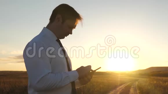商人平板电脑智能手机的手指触摸屏男性手拿着平板电脑在公园里查看电子邮件视频的预览图