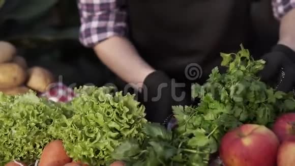 把女农民的双手戴着黑色手套整理有机食品沙拉土豆胡萝卜在农场市场的地位视频的预览图