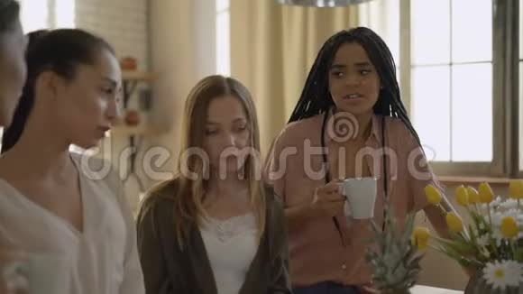 厨房里有5个女朋友喝茶谈论生活伤心的女孩互相支持视频的预览图