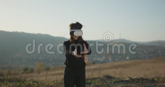年轻女性使用3D虚拟现实耳机女孩在vr耳机玩冒险游戏青少年娱乐休闲视频的预览图