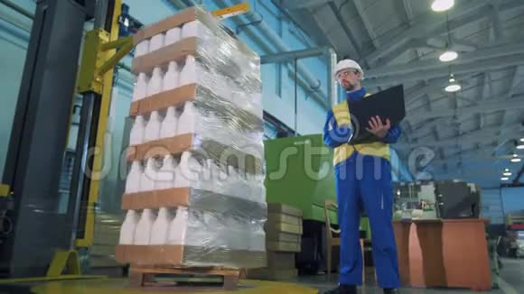 男工程师监督下的塑料罐自动包装视频的预览图