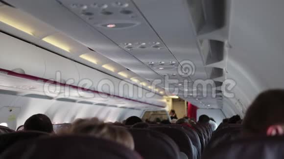 经济舱的乘客平静地坐在飞机舱内视频的预览图