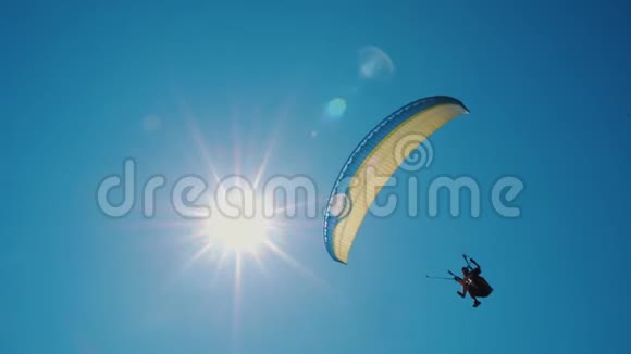 极端滑翔伞在晴朗的蓝天上飞行阳光照进照相机视频的预览图