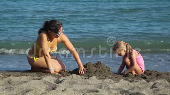 妈妈和女儿在沙滩上玩耍视频的预览图
