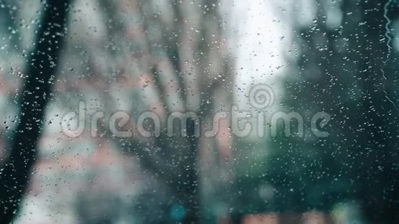 时间在车窗外转悠下起雨来滴在玻璃上水滴滑下挡风玻璃特写视频的预览图