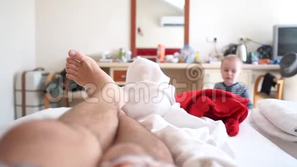 男人躺在床上一个小孩走在背景上动作缓慢视频的预览图