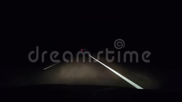 在夜间轨道上从出租车上看到大灯照亮了汽车前面的沥青迎面而来的车辆的大灯是黑色的视频的预览图