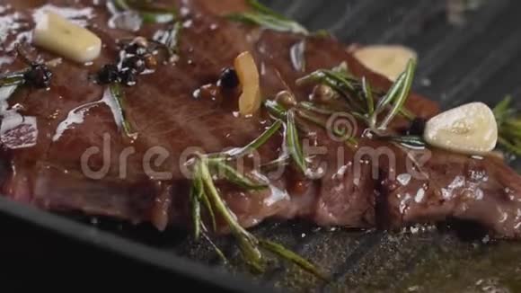 美味多汁的新鲜牛肉牛排上面滴着油或融化的黄油经过调味视频的预览图