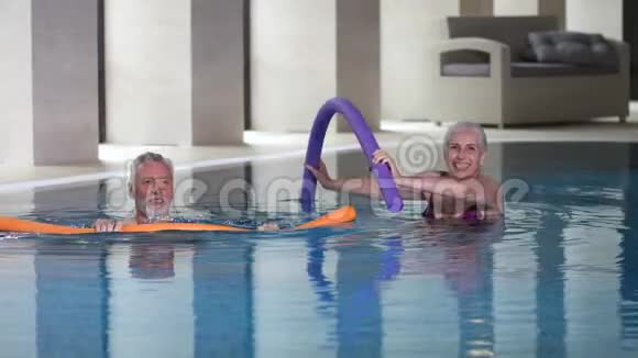 健康的老年夫妇在游泳池里做水上有氧运动视频的预览图
