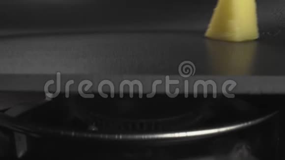黄色的三角形黄油卷过加热的平底锅融化变成液体视频的预览图