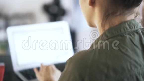 一个女人在办公室里用笔记本电脑打字的倾斜度视频的预览图