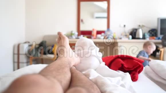 男人躺在床上一个小男孩走在背景上慢动作视频的预览图