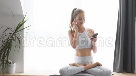 美丽的白种人女运动员在每天的晨练之后用无线耳机享受休息和音乐视频的预览图