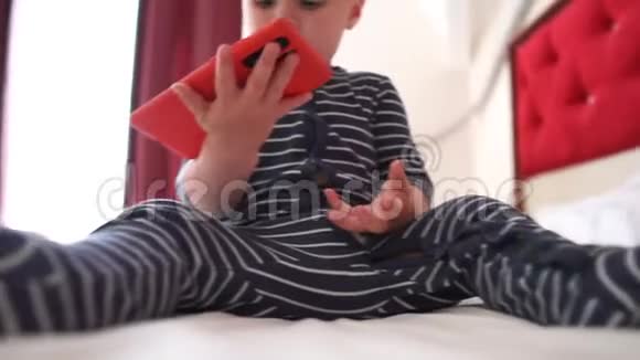 小宝宝高兴地慢动作地把智能手机扔到一张大床上视频的预览图