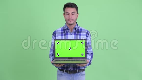 穿着年轻的西班牙裔男子展示笔记本电脑并得到坏消息视频的预览图