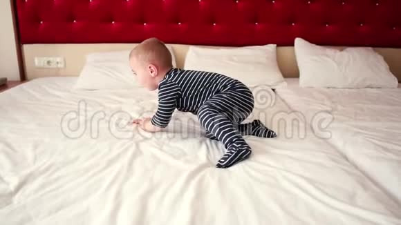 一个小男孩快乐地跳着慢悠悠地在大床上翻滚视频的预览图