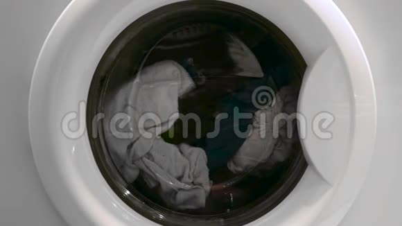 洗衣机门的特写衣服在里面旋转概念洗衣机的特写镜头视频的预览图