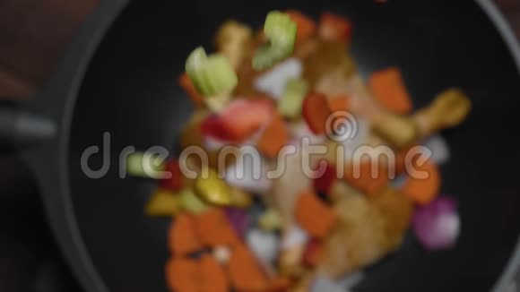 在热锅或厨房或餐厅的炒锅中掉落蔬菜的俯视图视频的预览图