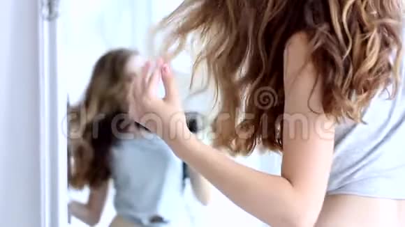 快乐的年轻女子在家洗澡后吹干头发视频的预览图