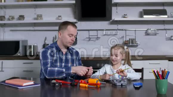 爸爸用扳手向小女孩展示动作视频的预览图