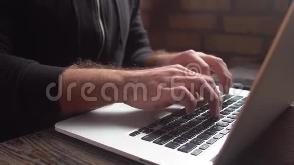 在阁楼咖啡厅用笔记本电脑键盘打字的人近景在笔记本电脑键盘上写字的人的手视频的预览图
