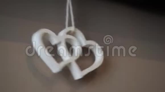 双木白色的心挂在弦上摇摆在米色的墙上视频的预览图