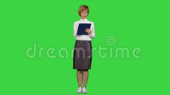 年轻女商人带着平板电脑在绿色屏幕上提问的肖像Chroma键视频的预览图