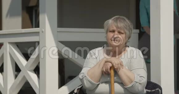 保健护士在阳光明媚的一天在疗养院拍摄的红色C片上为老妇人微笑快乐的户外活动铺上枕头视频的预览图