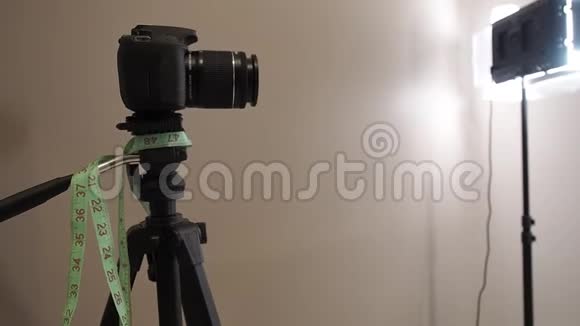 相机在摄影工作室的三脚架上三脚架上挂着一个腰围表视频的预览图