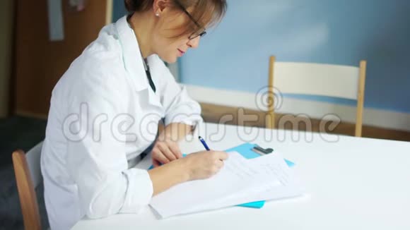 女医生开处方在医疗办公室的办公桌上填写病史国际医生日视频的预览图