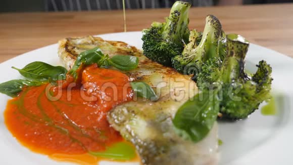 在餐馆做健康的食物烹饪主要课程将一大片鱼片放在白色盘子里视频的预览图