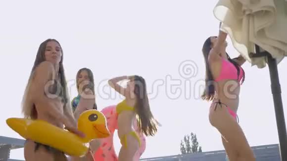 周末在昂贵的度假胜地游泳池边穿着泳装和迷人的女孩结伴而行视频的预览图