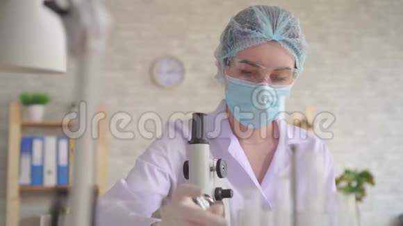 一位女性实验室助理的画像用显微镜进行并记录研究视频的预览图