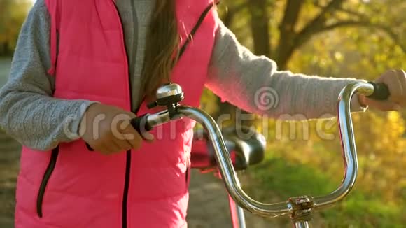 女孩卷一辆自行车手握曲线轮孩子在路上骑自行车旅行运动步行少女骑自行车A视频的预览图